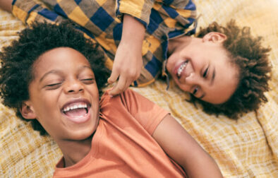 Boy, children and outdoor in park, picnic or top view for love, care or bonding to relax in sunshine. African siblings, kids and happy in garden, comic and funny game for smile, summer and holiday.